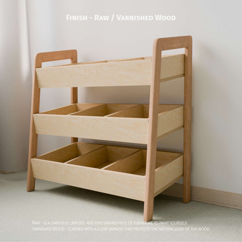 The image shows an empty Montessori-style toy organizer with a choice of raw or varnished wood finish. It features three tiers of open bins made from natural wood, ideal for organizing children's toys. The raw wood option is finely sanded, ready for painting or personal finishing, while the varnished wood is coated with a clear varnish to protect and highlight the natural wood grain.