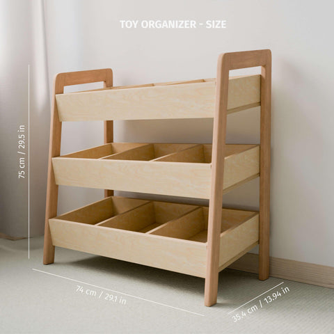  The image features an empty Montessori-style toy organizer made of natural wood, with three tiers of open bins. The organizer's dimensions are clearly labeled: it stands 75 cm (29.5 inches) tall, 74 cm (29.1 inches) wide, and 35.4 cm (13.94 inches) deep. This functional design promotes easy access and organization for children, encouraging independence and tidy habits.