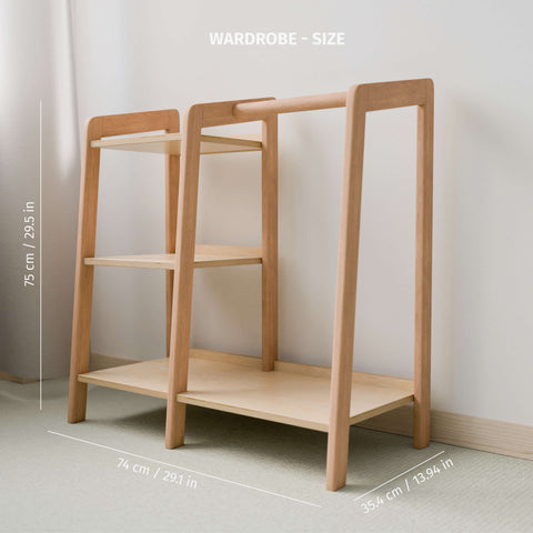 The image shows an empty Montessori-style wardrobe made of natural wood, highlighting its dimensions. The wardrobe stands 75 cm (29.5 inches) tall, 74 cm (29.1 inches) wide, and 35.4 cm (13.94 inches) deep. It features both a hanging rod and shelving space, providing an organized and accessible solution for children's clothing storage.