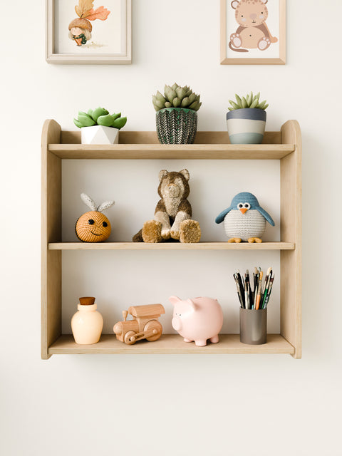 Front close-up of a Montessori wall-mounted shelf, neatly organized with toys, plants, and art supplies, perfect for a modern nursery.