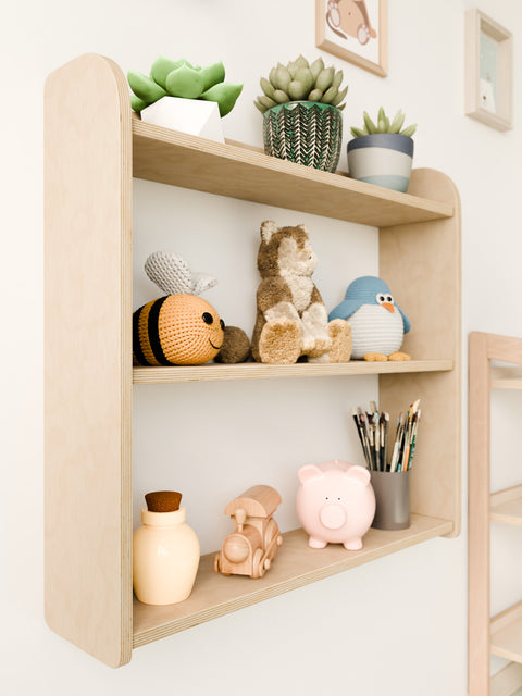 Close-up side view of a Montessori-inspired wall-mounted shelf, showcasing toys, plants, and a wooden design perfect for a child's room.